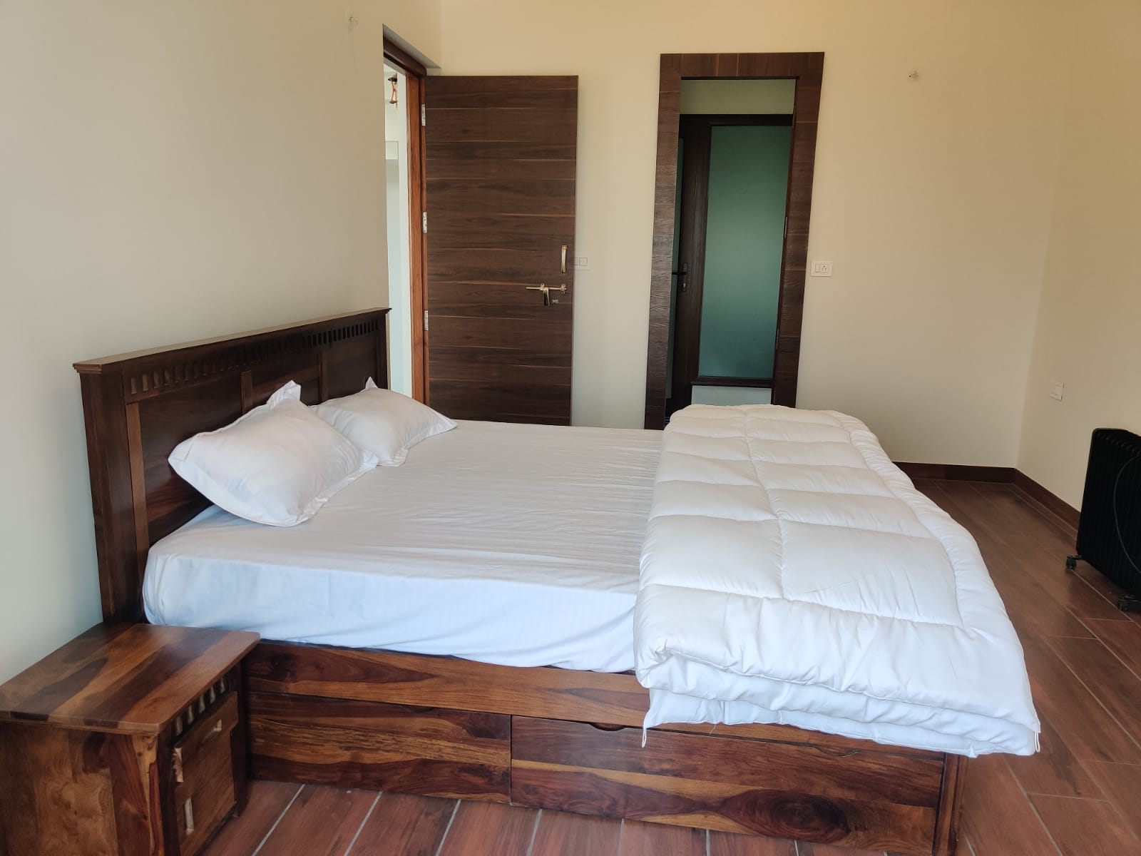 Cozy bedroom with sheesham wood bed and warm flooring
