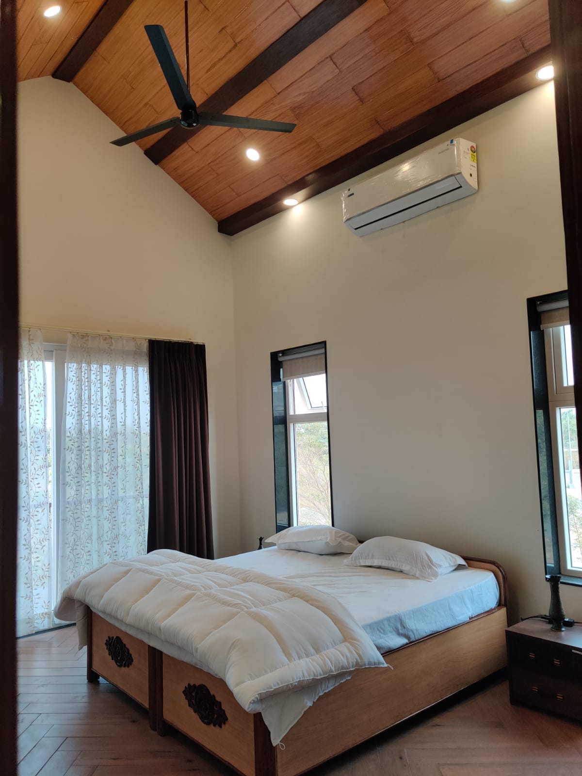Spacious bedroom with vaulted wooden ceiling and AC