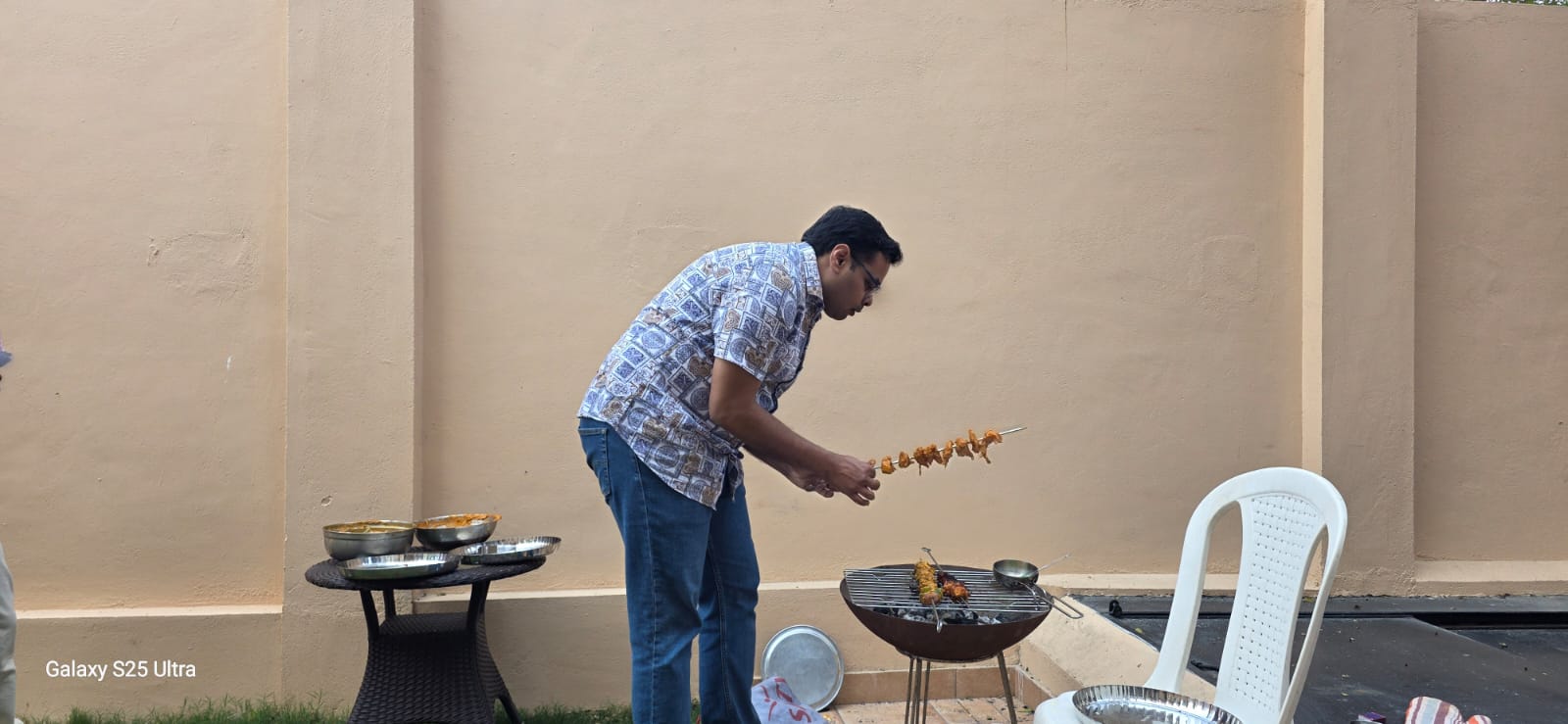 Host grilling kebabs on the outdoor BBQ