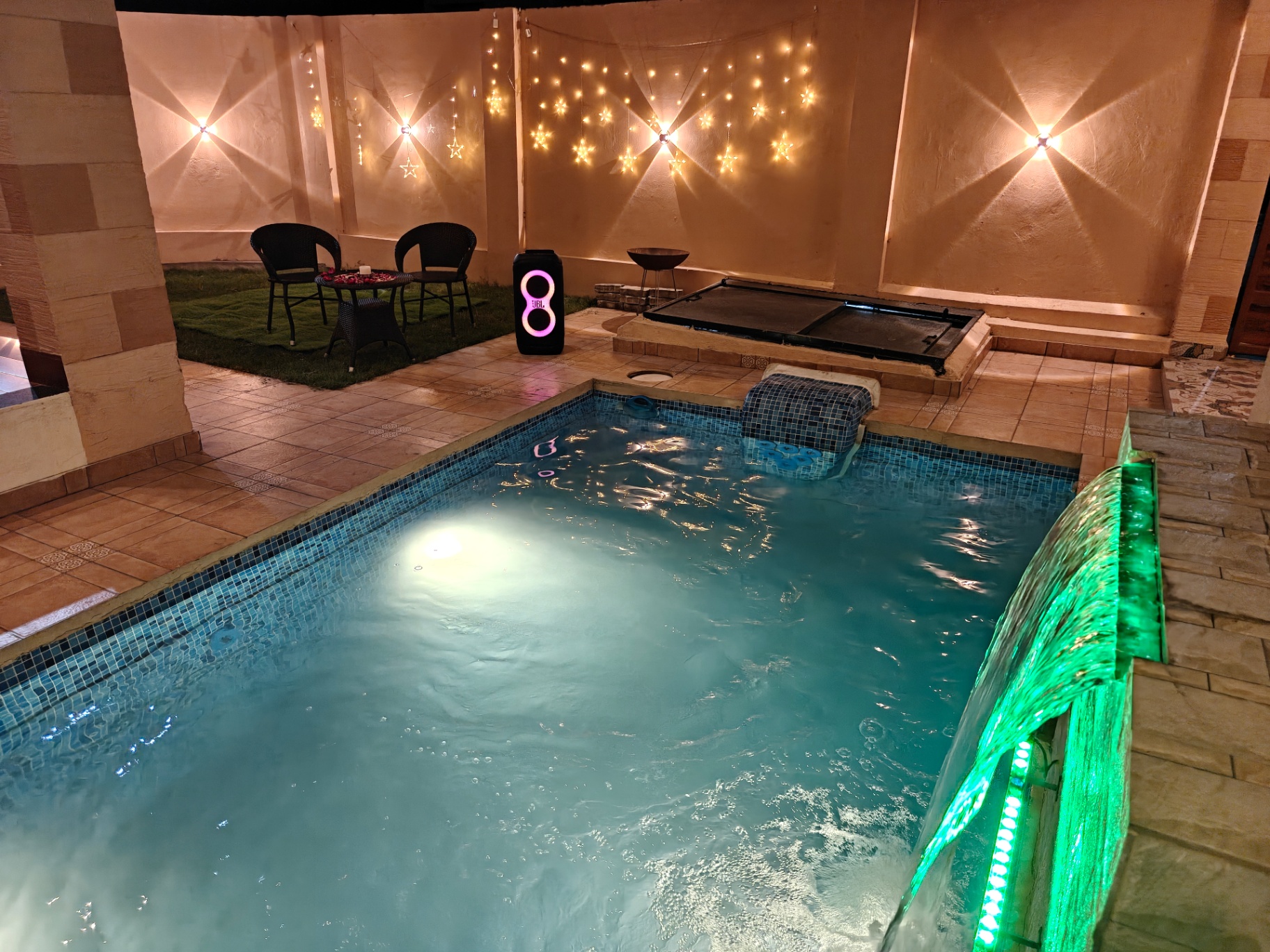 Pool with cascading water feature and star lights