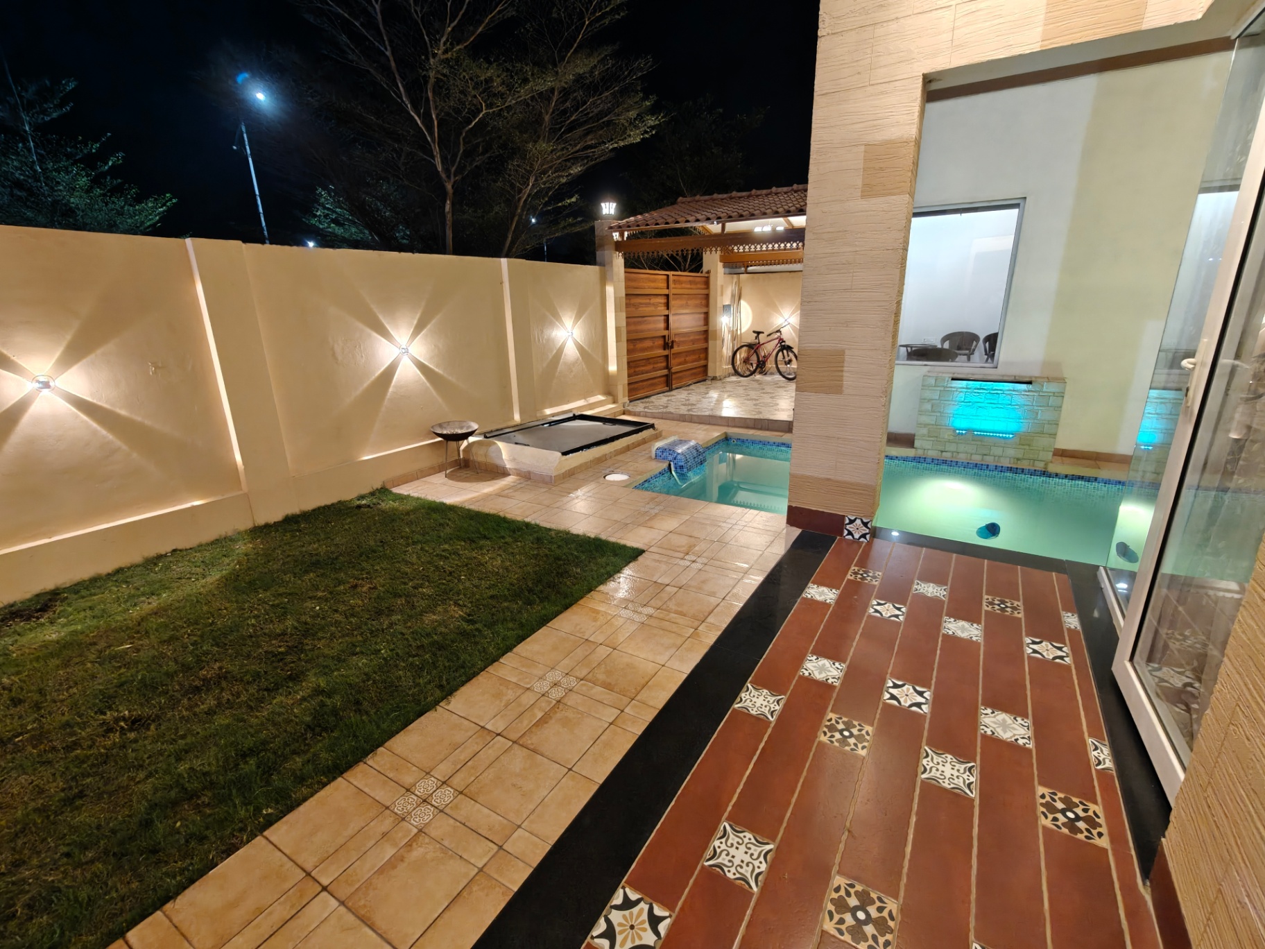 Pool with lawn and decorative tiled patio