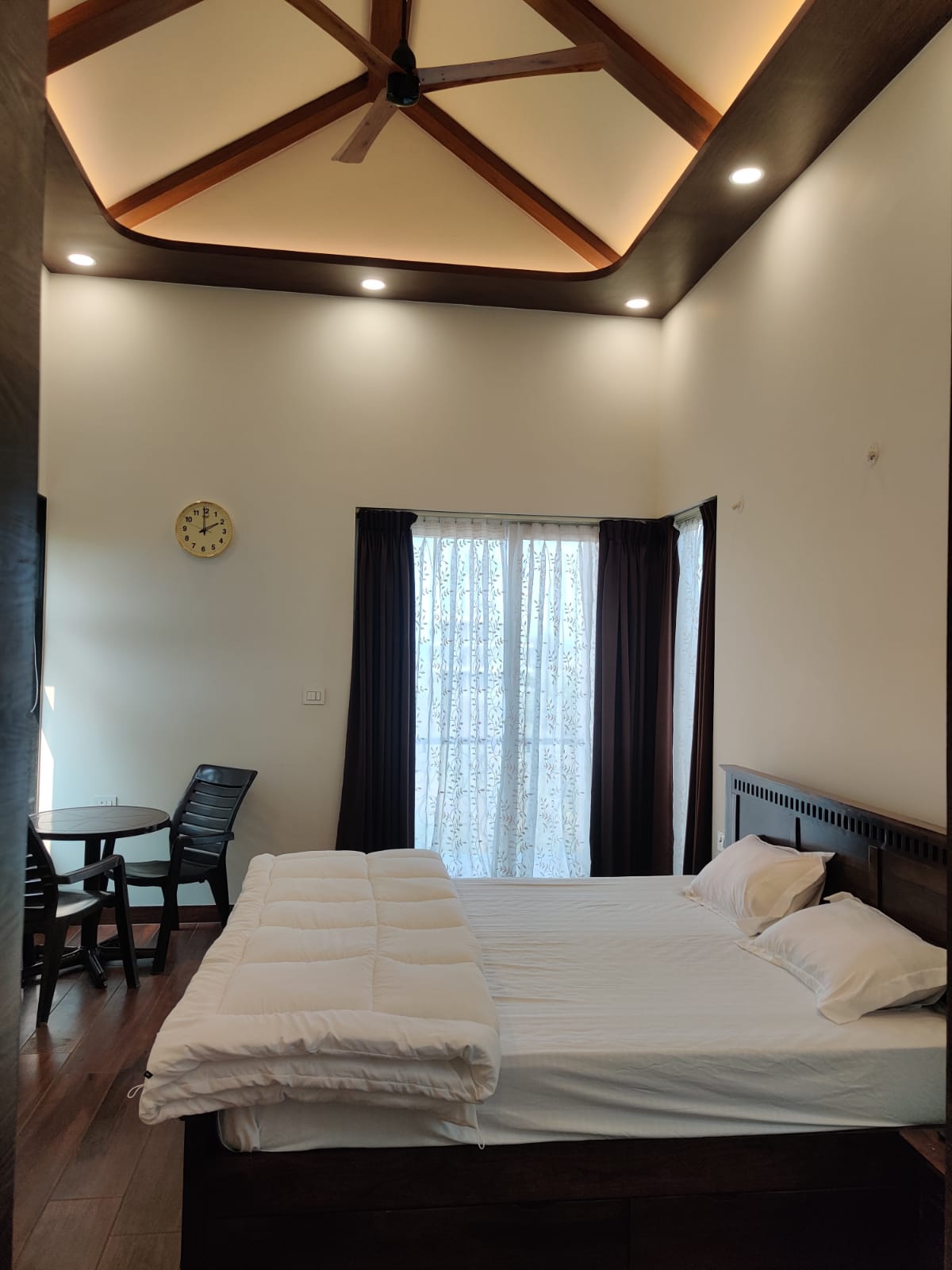 Bedroom with vaulted ceiling, exposed wooden beams and balcony